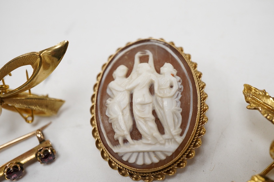 A collection 9ct brooches to include a shell cameo carved with the Three Graces, an amethyst set floral spray brooch, a cultured pearl set ribbon brooch, a garnet set bar brooch and a cultured pearl set stick pin, togeth